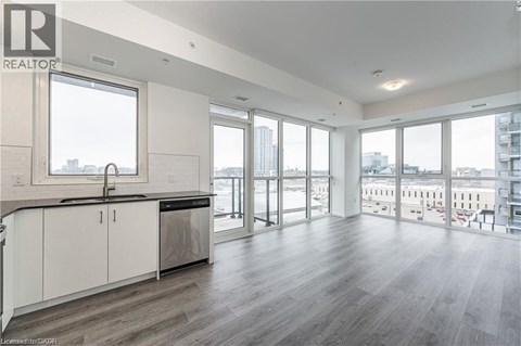 A spacious kitchen with white cabinets and a large window overlooking the city.