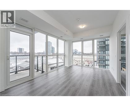 A spacious room with a view of the city through large windows.