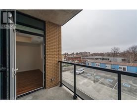 A balcony with a view of a parking lot and buildings.