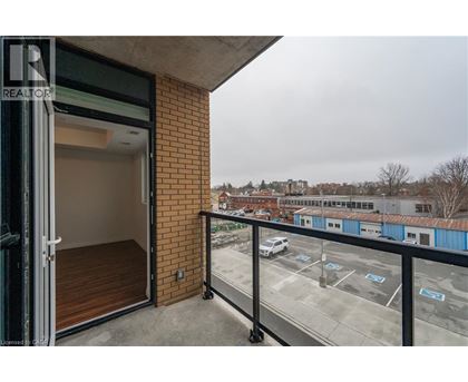 A balcony with a view of a parking lot and buildings.