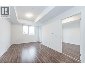 A spacious room with wooden flooring and white walls.