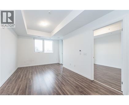 A spacious room with wooden flooring and white walls.