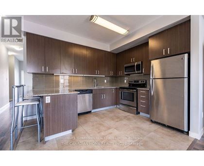 A kitchen with brown cabinets and stainless steel appliances.