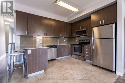 A kitchen with brown cabinets and stainless steel appliances.
