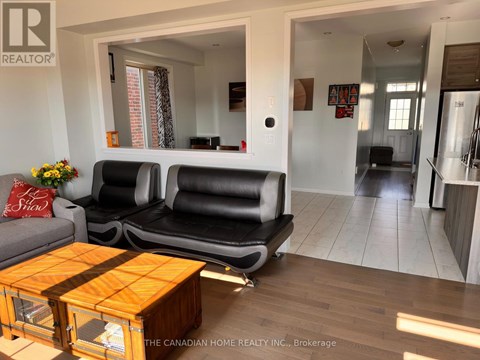 A living room with a black couch and a wooden coffee table.