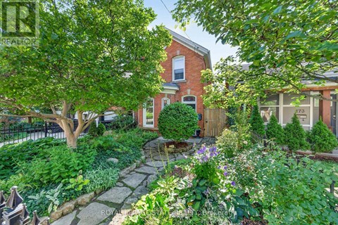 A garden with a stone pathway and a variety of plants and flowers.