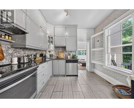 A modern kitchen with a stainless steel dishwasher and wooden flooring.