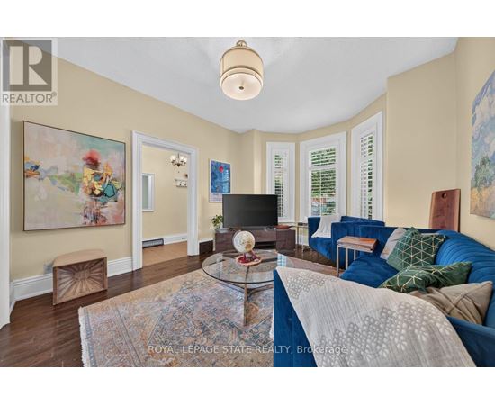 A living room with a blue couch and a glass coffee table.