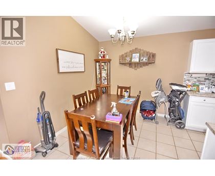 A dining room with a wooden table and chairs.