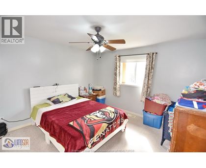 A bedroom with a bed covered in a "Spartans" blanket.