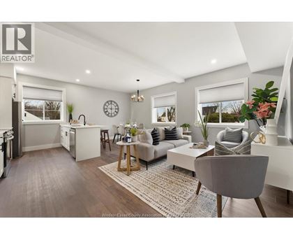 A well-lit, modern living room with a grey sofa and a wooden coffee table.