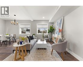 A well-lit living room with a grey sofa, a wooden coffee table, and a grey armchair.