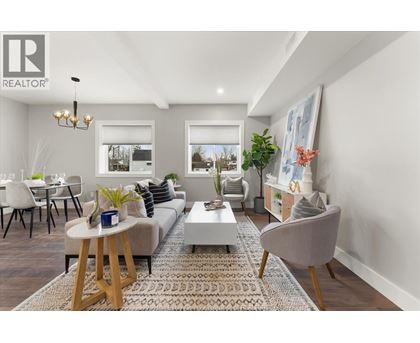 A well-lit living room with a grey sofa, a wooden coffee table, and a grey armchair.