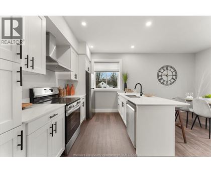 A modern kitchen with white cabinets and a large island.