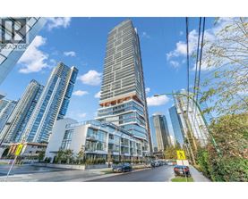 A tall building with a curved glass facade stands in front of other buildings.