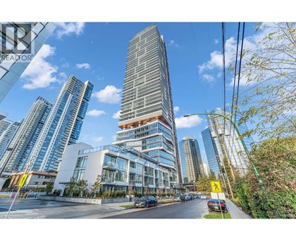 A tall building with a curved glass facade stands in front of other buildings.