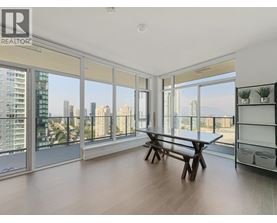 A spacious room with a table and bench, large windows, and a view of the city.