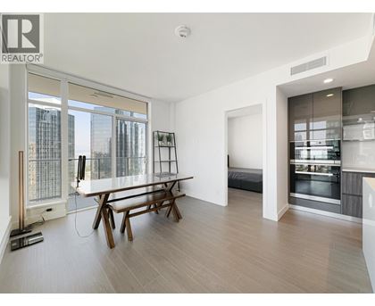 A modern living room with a dining table and a large window overlooking the city.