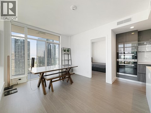 A modern living room with a dining table and a large window overlooking the city.