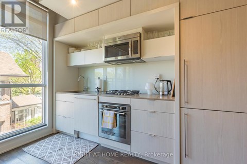 A modern kitchen with a stove top oven and a microwave above it.