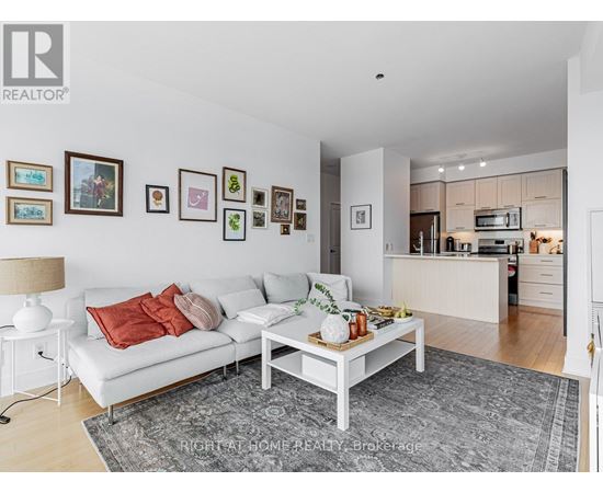 A living room with a white couch and a grey rug.