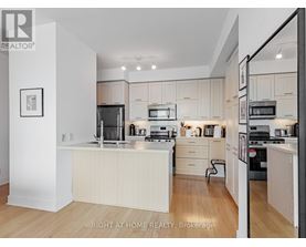 A modern kitchen with white cabinets and appliances.