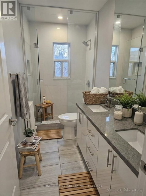 A bathroom with a glass shower stall and a toilet.