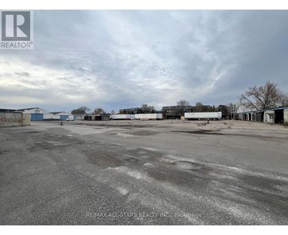 A large, empty parking lot with a cloudy sky overhead.