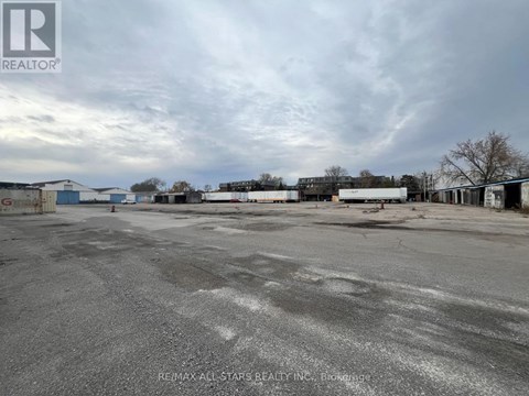 A large, empty parking lot with a cloudy sky overhead.