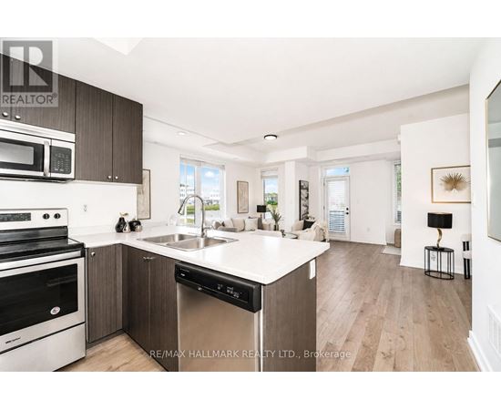 A modern kitchen with dark wood cabinets and stainless steel appliances.