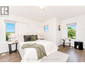 A bedroom with a large bed and a window with blinds.