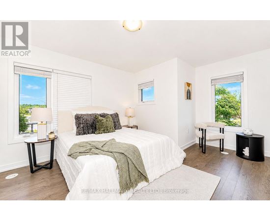 A bedroom with a large bed and a window with blinds.