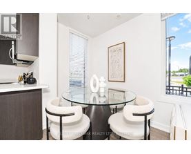 A modern dining room with a glass table and white chairs.