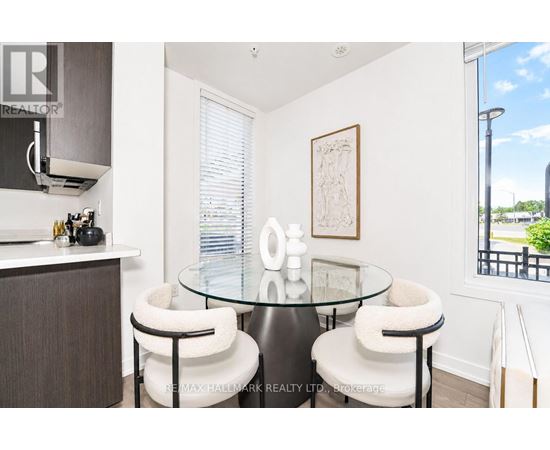 A modern dining room with a glass table and white chairs.