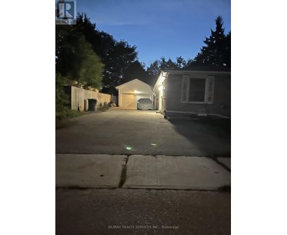 A house with a garage is illuminated by lights at night.