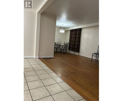 A room with a wooden floor and a white tiled floor.