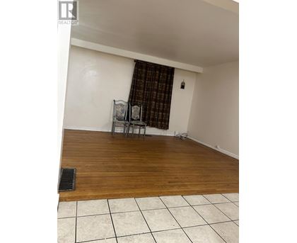 A room with a wooden floor and a chair with a table.