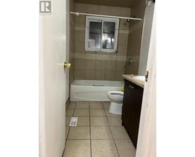 A small bathroom with a toilet, tub, and sink.