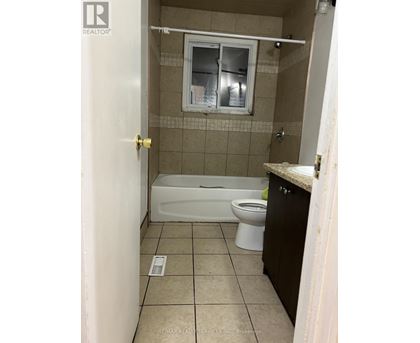 A small bathroom with a toilet, tub, and sink.