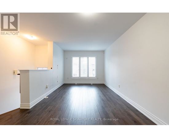 A spacious room with wooden floors and white walls.
