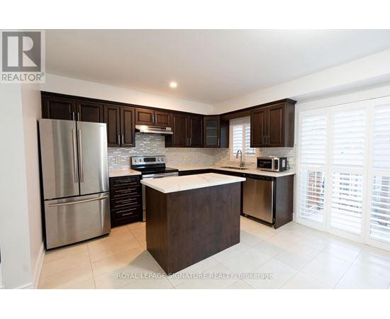 A modern kitchen with dark brown cabinets and stainless steel appliances.
