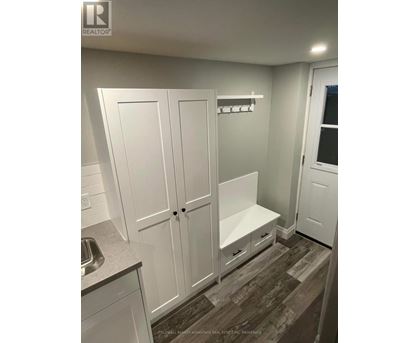 A white kitchen with a sink and cupboards.
