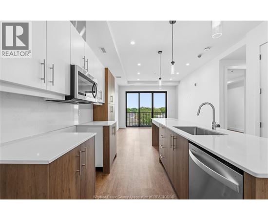 A modern kitchen with wooden cabinets and stainless steel appliances.