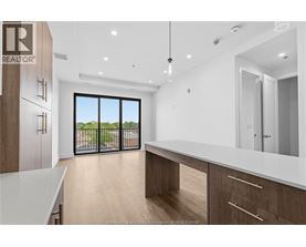 A modern kitchen with wooden cabinets and a large window.