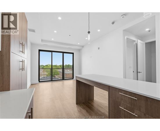 A modern kitchen with wooden cabinets and a large window.
