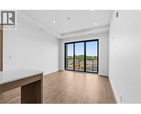 A spacious room with a view of a fenced area outside the window.