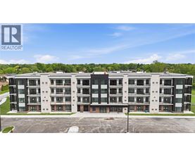 A large apartment complex with a parking lot in front.