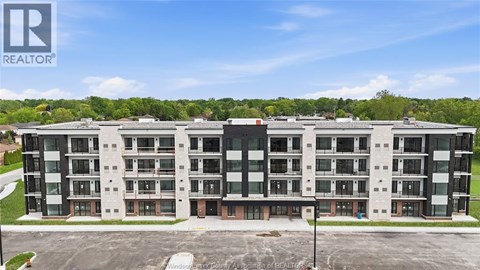 A large apartment complex with a parking lot in front.