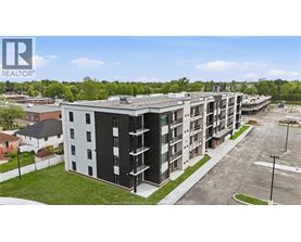 A large apartment complex with multiple buildings and a parking lot in front.
