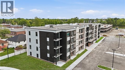 A large apartment complex with multiple buildings and a parking lot in front.